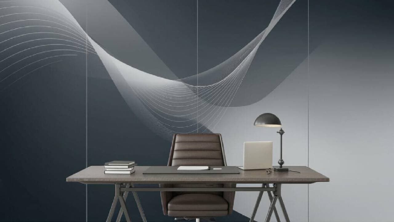 A modern office space featuring a sleek wooden desk with a laptop, a desk lamp, and a stack of notebooks. Behind the desk is a dark, artistic wall with abstract white wave patterns. A brown leather chair is positioned in front of the desk, completing the minimalist setup.